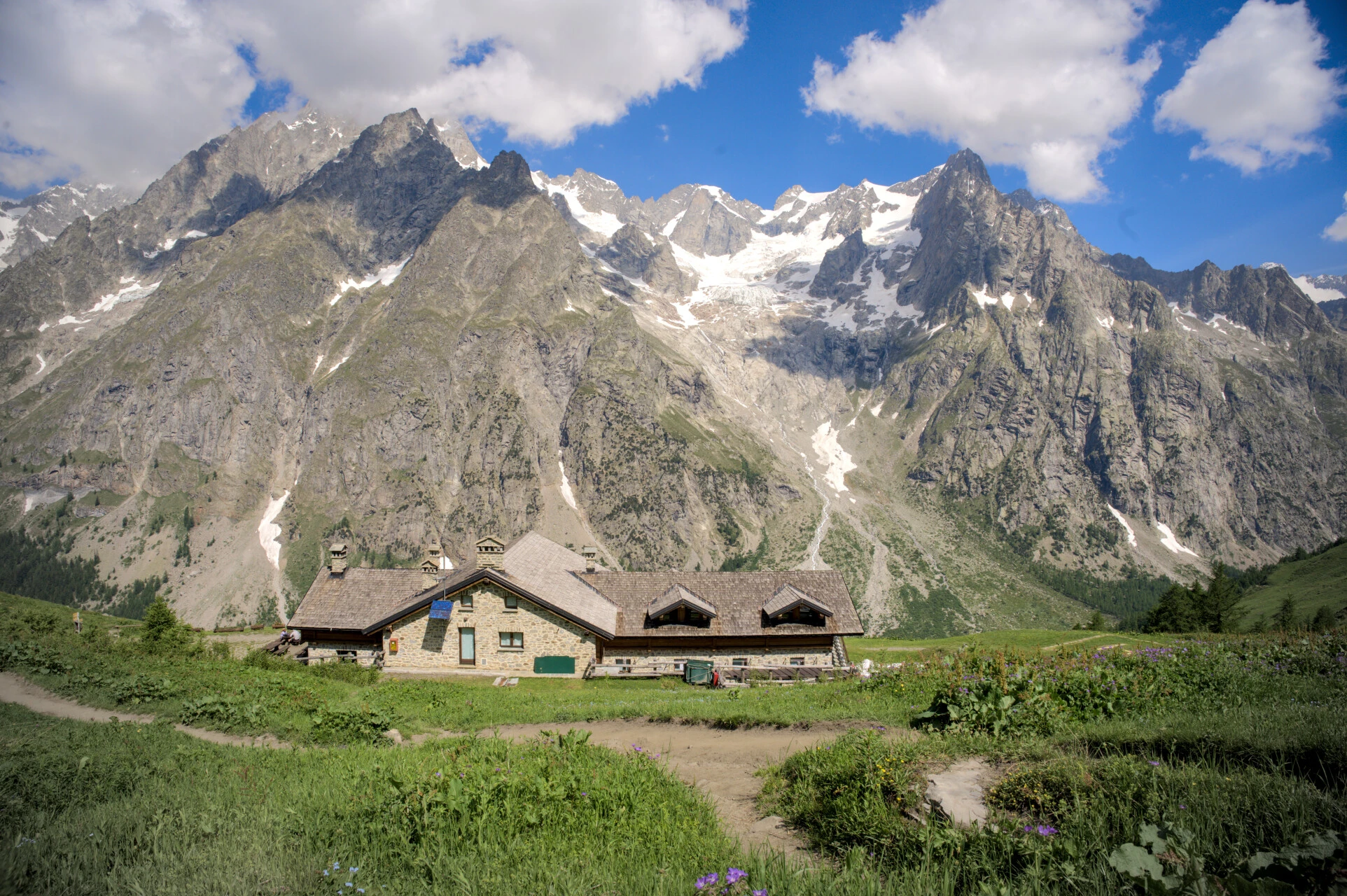 The Refuge Bonatti in its alpine meadow facing the Grandes Jorasses